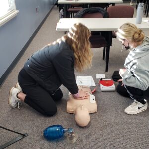 students working with mannequin in health occupation class 