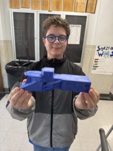 Student holding 3-D printed historic snowplow