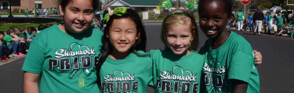 four girls looking at camera in shamrock pride shirts